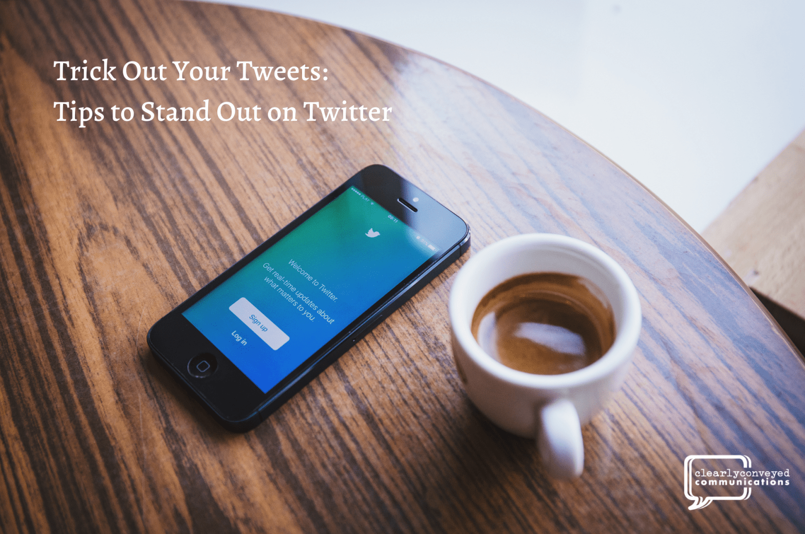 A smartphone with the Twitter app open and a cup of coffee sit on a table.