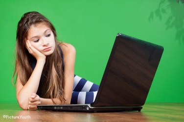 A young girl uses a laptop